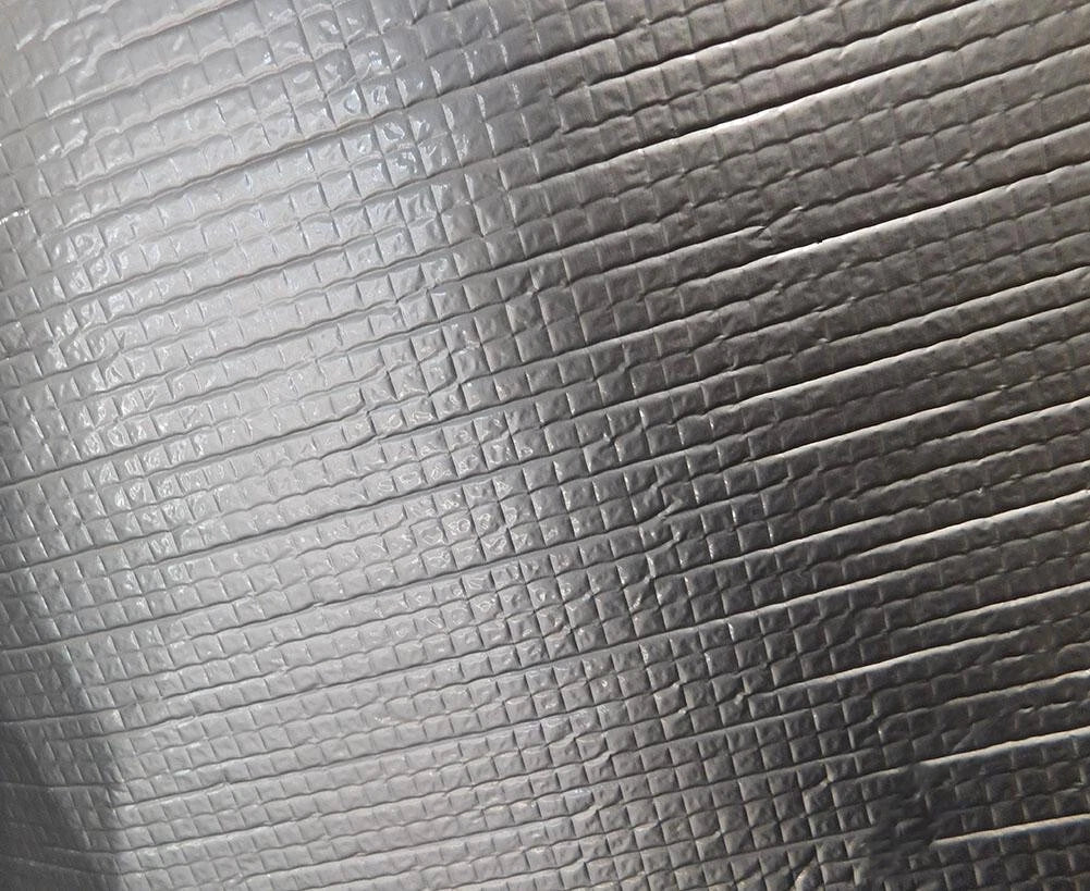 Close-up texture of automotive self-adhesive sound deadener and heat insulation material